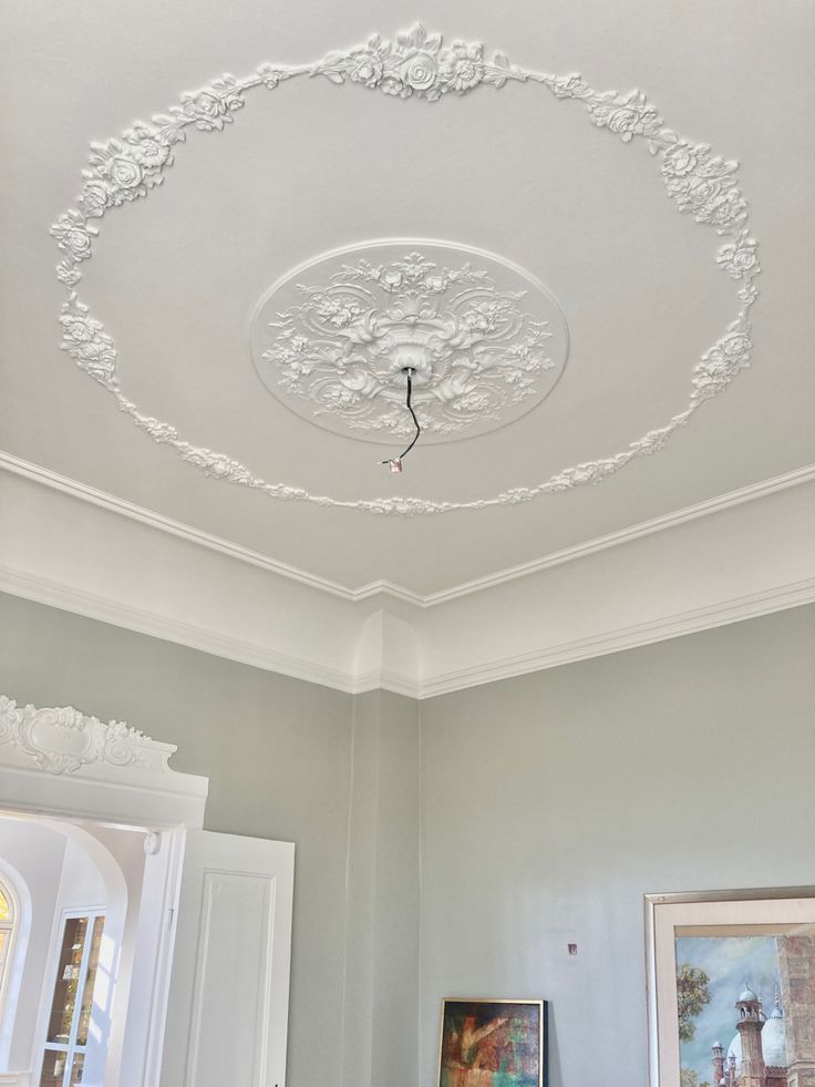 the ceiling is decorated with white paint and flowers on it's trimmings