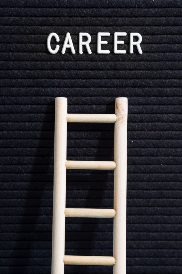 a ladder leaning against a black wall with the word career written on it in white letters