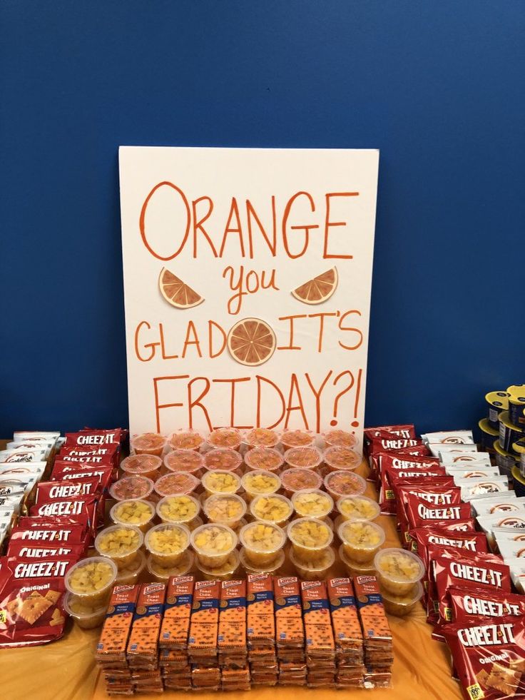 an orange you glad it's friday sign is displayed on a table full of snacks