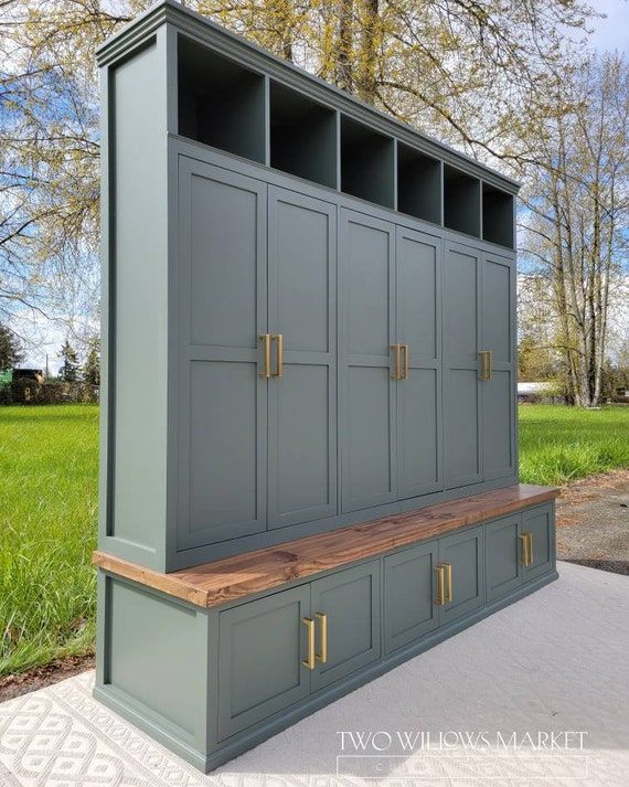 a large gray cabinet sitting on top of a cement floor next to a green field