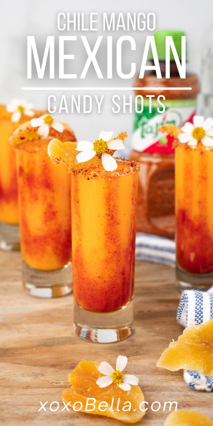 three glasses filled with mexican candy shots on top of a wooden table next to pineapple slices