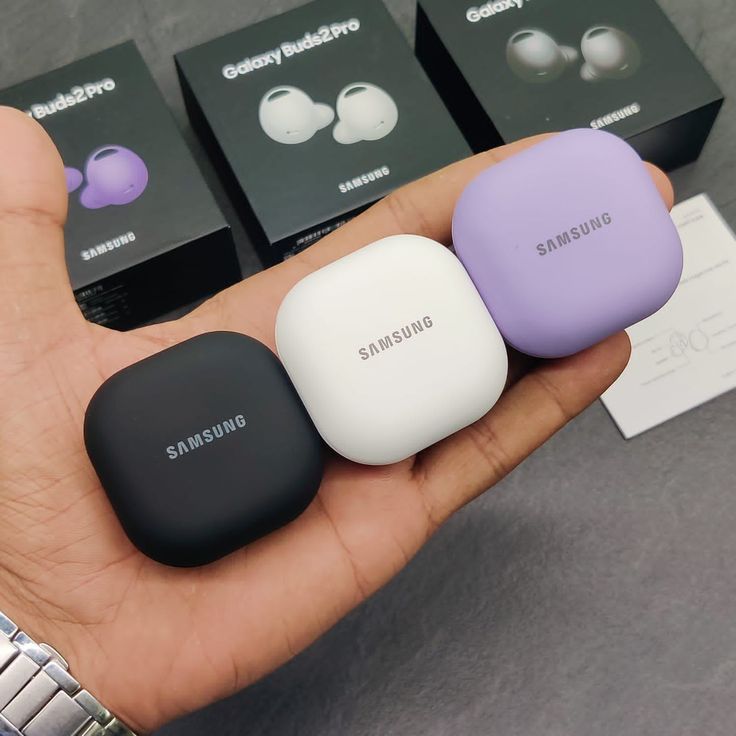 three different colors of the samsung buds in their hand