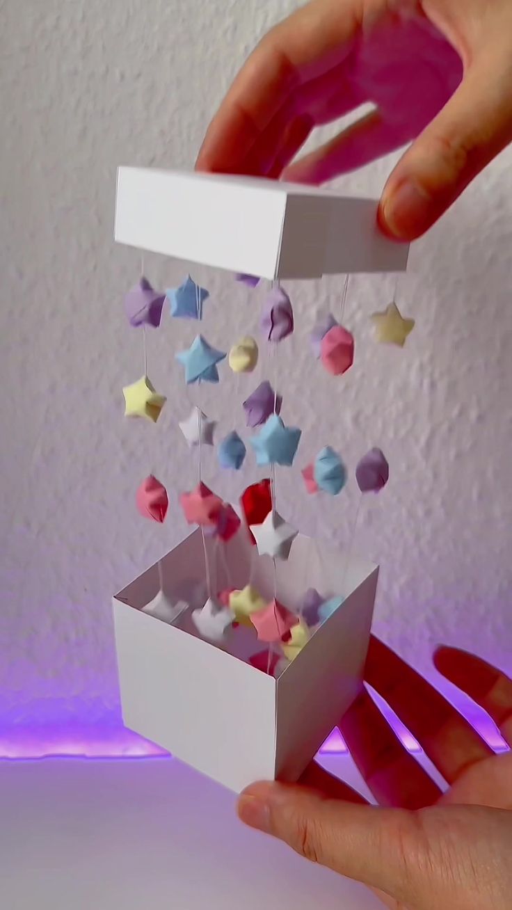 someone is holding a box with tiny stars coming out of it