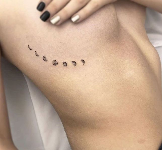 a woman's back with the moon and phases tattoo on her left side ribcage