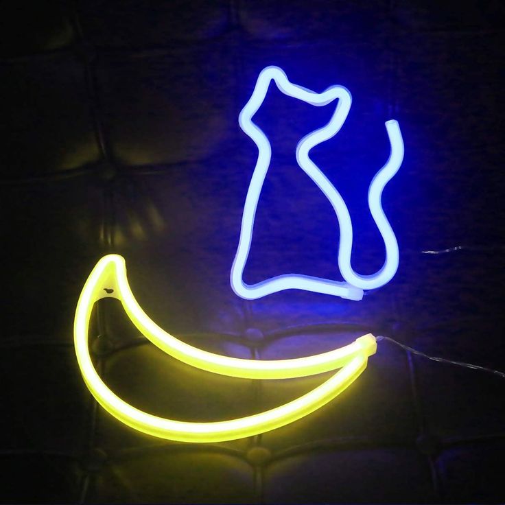 a neon sign that is on the side of a wall with a banana in front of it