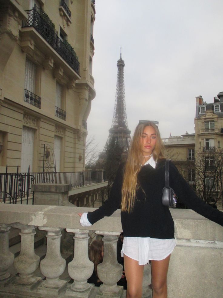 a woman standing in front of the eiffel tower