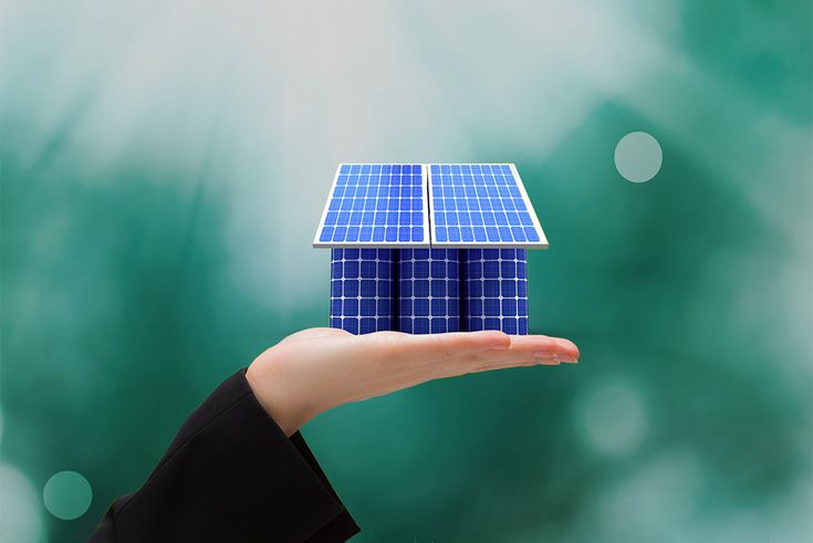 a hand holding a small model of a solar panel