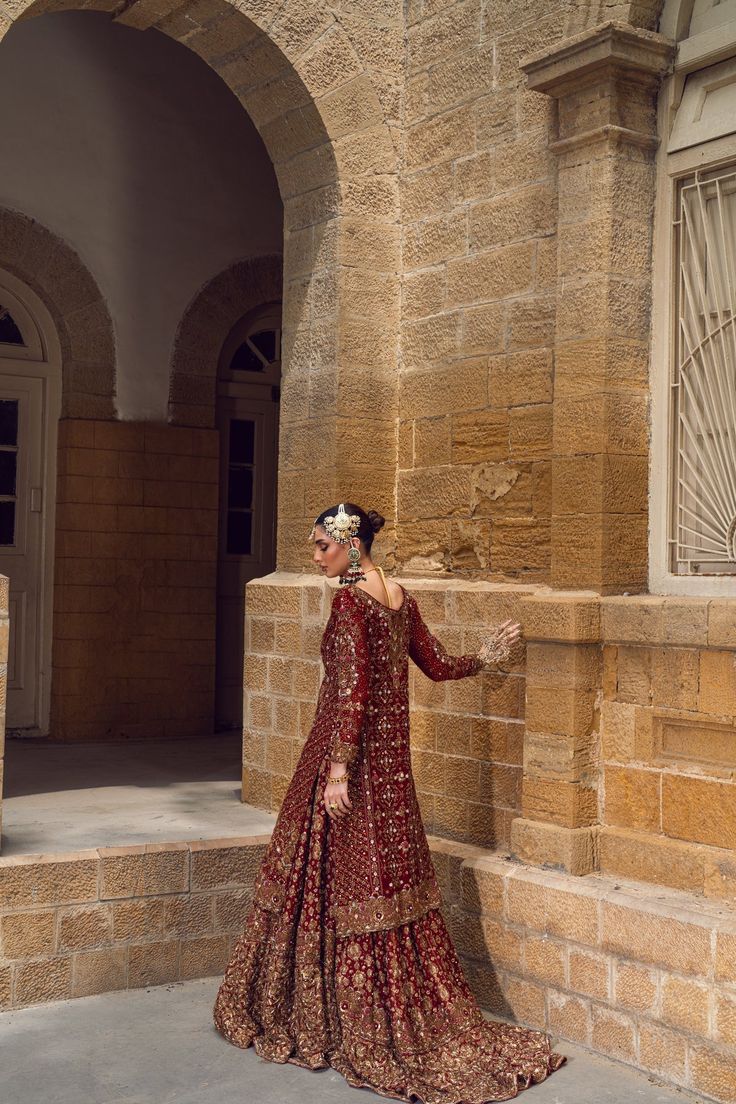 Pakistani Bridal Dress in Red Lehenga and Kameez Style is embellished with the hand-crafted details of zardosi, dabka, and motifs. Perfect stitching and premium quality fabric make this Lehenga Dress an epitome of beauty and your foremost priority for the wedding. Lehenga Kameez: The stunning kameez in an alluring red color is beautifully embellished with the intricate zardosi, dabka, resham french knots, threads, motifs, dabka, naqshi, zari, and sequins. Premium quality khaadi net fabric, kamdaani work, and perfect stitching make this Pakistani Bridal Dress a perfect choice to have a gorgeous wedding look. Red Lehenga: The embellished kameez is paired with Bridal Lehenga, creating a lavish Pakistani Bridal Outfit. The Farshi Lehenga has an alluring red shade and is gracefully emblazoned w Red Anarkali Set With Dabka For Reception, Red Traditional Wear With Dabka For Reception, Red Floor-length Sharara With Dabka Work, Semi-stitched Red Lehenga With Dabka Detailing, Red Semi-stitched Choli With Dabka Details, Red Semi-stitched Choli With Dabka, Traditional Dabka Dresses For Reception, Red Dabka Lehenga For Eid, Traditional Hand Embellished Dresses For Eid