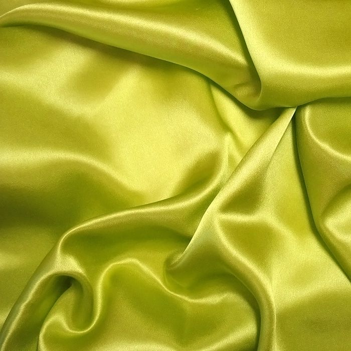 a close up shot of a lime green satin fabric with very soft folds on it