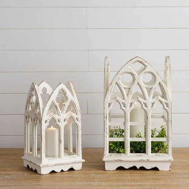 two white candle holders on a wooden table