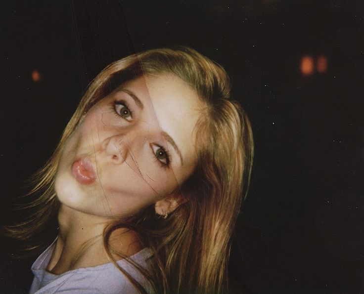 a woman with long blonde hair posing for the camera