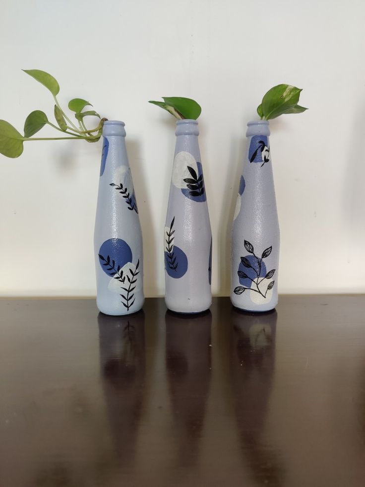 three blue and white vases with plants in them