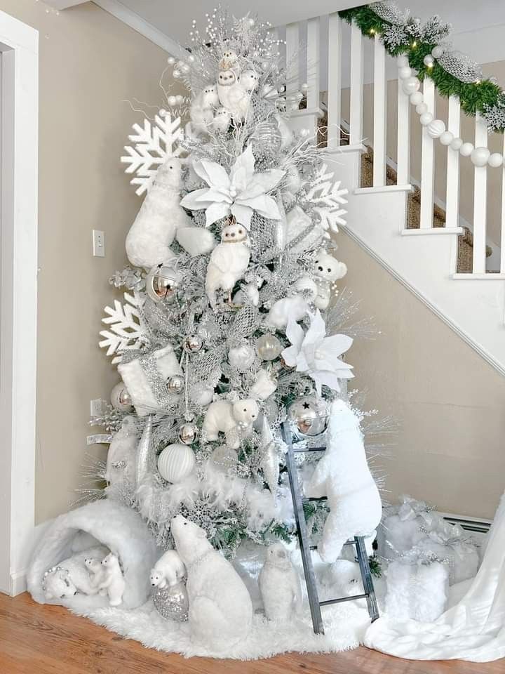 a white christmas tree with teddy bears and snowflakes on it in front of stairs