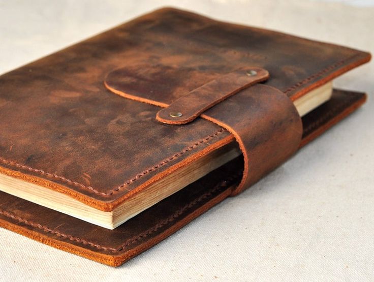 an open brown leather journal sitting on top of a table