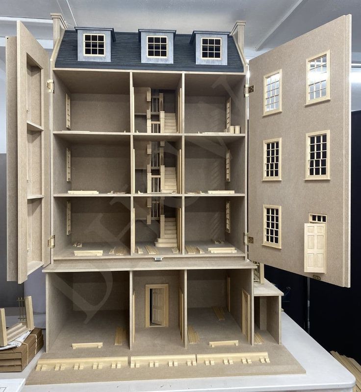 a doll house is shown on display in a room with wooden shelves and windows, all made out of plywood