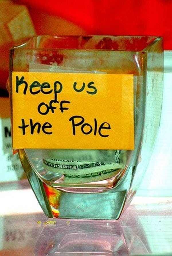 a glass cup with money in it and a sign that says keep us off the pole