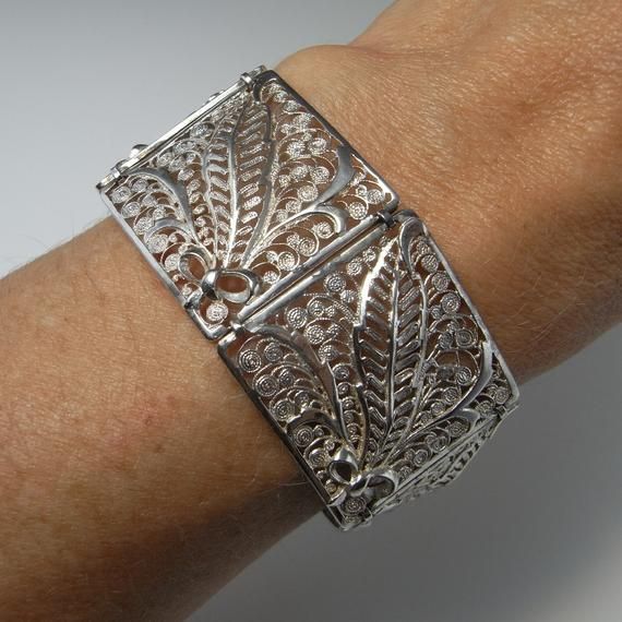 Here is an exceptional Art Nouveau completely handmade silver filigree bracelet circa 1890. The workmanship here is reminiscent of 18th century filigree in the quality and intricacy of this amazing piece. Each panel is entirely made by hand with silver wire twisted and wound into a fern and frond design each bouquet tied with a feminine bow. Amazingly each panel is not flat but the silver lace design is raised in relief with the central fern frond sitting higher to the rest of the panel. When th Elegant Luxury Antique Silver Cuff Bracelet, Wedding Filigree Bangle Bracelets, Antique Cuff Bracelet With Intricate Design For Formal Occasions, Victorian Sterling Silver Bracelet, Engraved For Formal Occasions, Elegant Engraved Ceremonial Cuff Bracelet, Elegant Ceremonial Engraved Cuff Bracelet, Victorian Sterling Silver Engraved Wedding Bracelet, Elegant Engraved Cuff Bracelet For Ceremonial Occasions, Antique Silver Wedding Bangle With Intricate Design