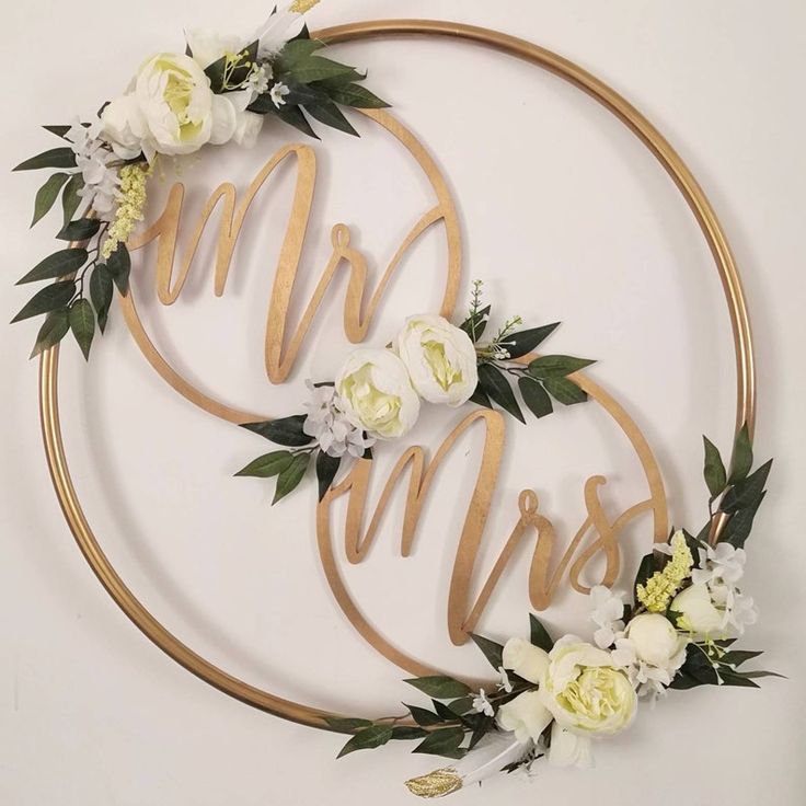 the bride and groom's initials are made out of wood, surrounded by flowers