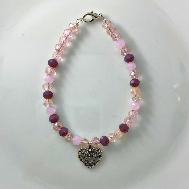 "🌸 Sign up for the Starfish by Kristan email list and get 15% off your order NOW! https://mailchi.mp/13833f6189a3/new-customers 🌸 Looking for high quality, affordable jewelry?  If so, this bracelet is for you!  This pink/clear 4mm round crystal bead bracelet with a silver heart charm. OUR BRACELETS ARE... *Made with high quality lava stones, semi-precious beads, silver, and glass beads *Tarnish free silver wire & gold wire, 925 silver, 1mm stretch cord, waxed linen cord *Crafted in house *Available in size 7.5\" CARE INSTRUCTIONS *Remove before swimming or showering *Do not use harsh chemicals  *Roll bracelet over hand, do not over stretch SHIPPING INFORMATION *Once I receive your order, I will ship out to you in the timeframe below *Orders are shipped in a padded mailer to ensure a safe