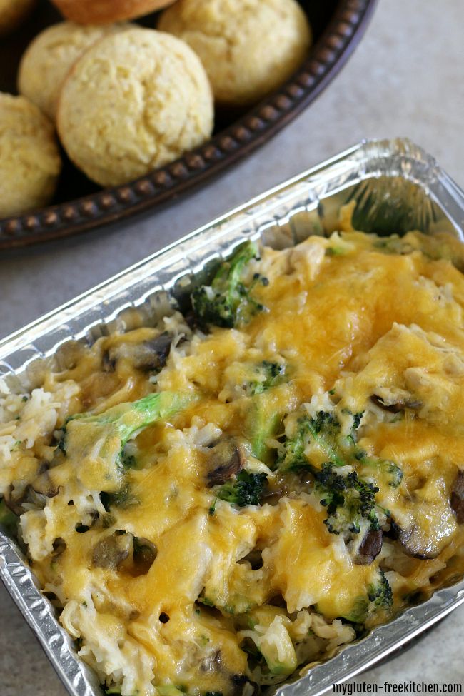 a casserole dish with broccoli and mushrooms in it next to some muffins