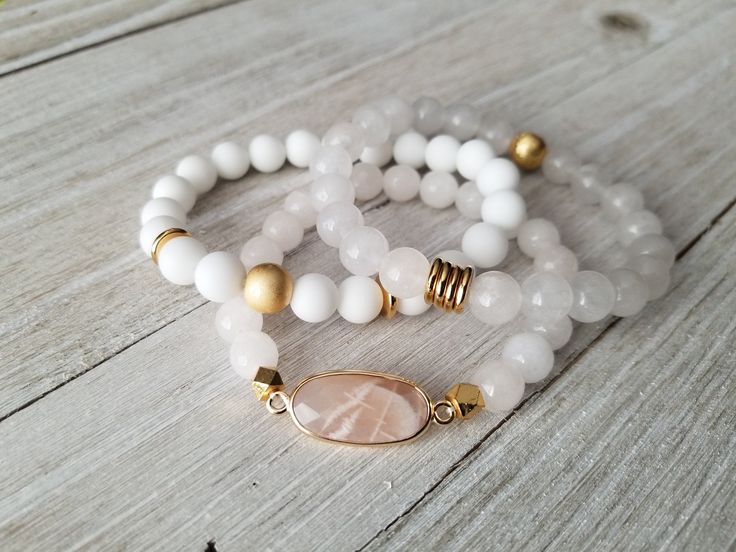 Gorgeous white stack features: -milky white with gold bead and spacers -matte white jade with matte gold hematite and gold spacers -white moonstone paired with a pink moonstone pendant. Pick one or all 3 of them. Choose your bracelet choice and your size from drop box. All your items will be packaged and shipped in a cotton filled kraft box. Adjustable White Gemstone Beaded Bracelets, White Gemstone Beads Stretch Bracelet As Gift, Adjustable White Beaded Bracelets With Gemstones, Adjustable White Crystal Bracelet With Gemstone Beads, Adjustable White Pearl Bracelet With Gemstone Beads, White Pearl Bracelet With Gemstone Beads For Spiritual Wear, White Stackable Crystal Bracelet As Gift, White Spiritual Stretch Bracelet With Gemstone Beads, Spiritual White Pearl Bracelet With Gemstone Beads