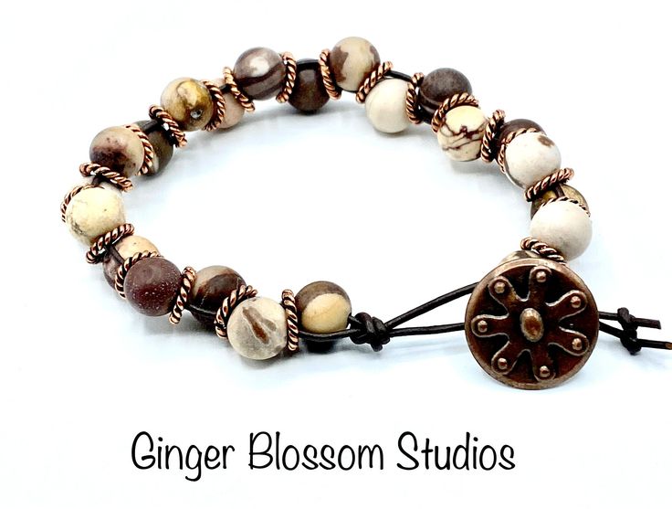 This is a handcrafted cream, brown and copper bracelet fashioned onto a dark brown leather cord. The leather is hand knotted on one end for the closure loop. A antique copper button was chosen for the closure. The bracelet is 7 1/2 inches in length and 1/2 inch wide. This bracelet will stack beautifully with other bracelets.  Thank you for visiting our shop! Goddess Bracelet, Jasper Bead Bracelet, Jasper Bracelet, 108 Bead, Copper Rings, Copper Bracelet, Jasper Beads, Dark Brown Leather, Antique Copper