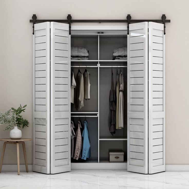 an open closet with clothes hanging on the doors