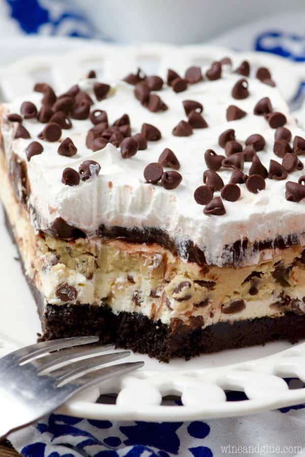 a white plate topped with a piece of cake covered in chocolate chips and marshmallows