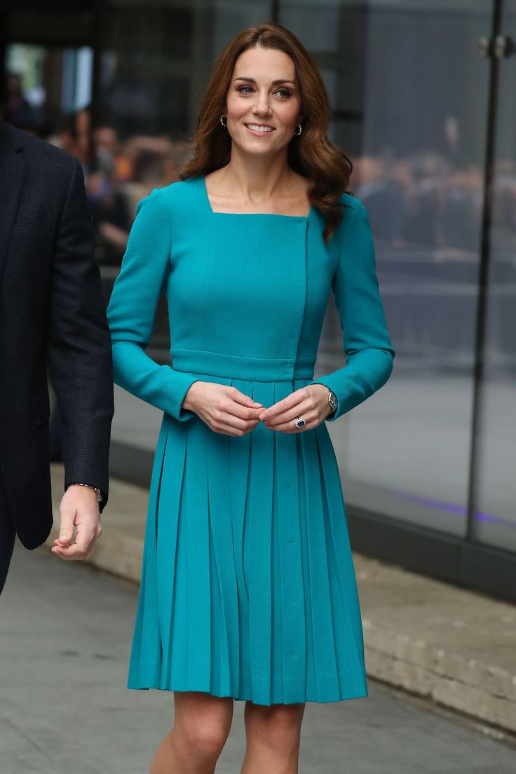 a woman in a blue dress is walking down the street