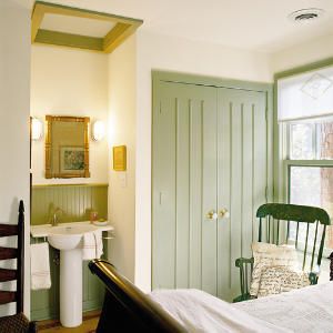 a bedroom with green painted walls and white bedding