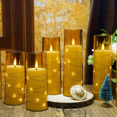 lighted candles sitting on top of a wooden table