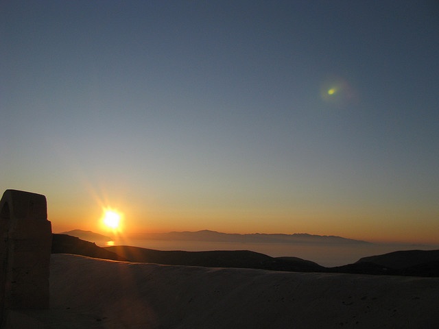 the sun is setting over some sand dunes