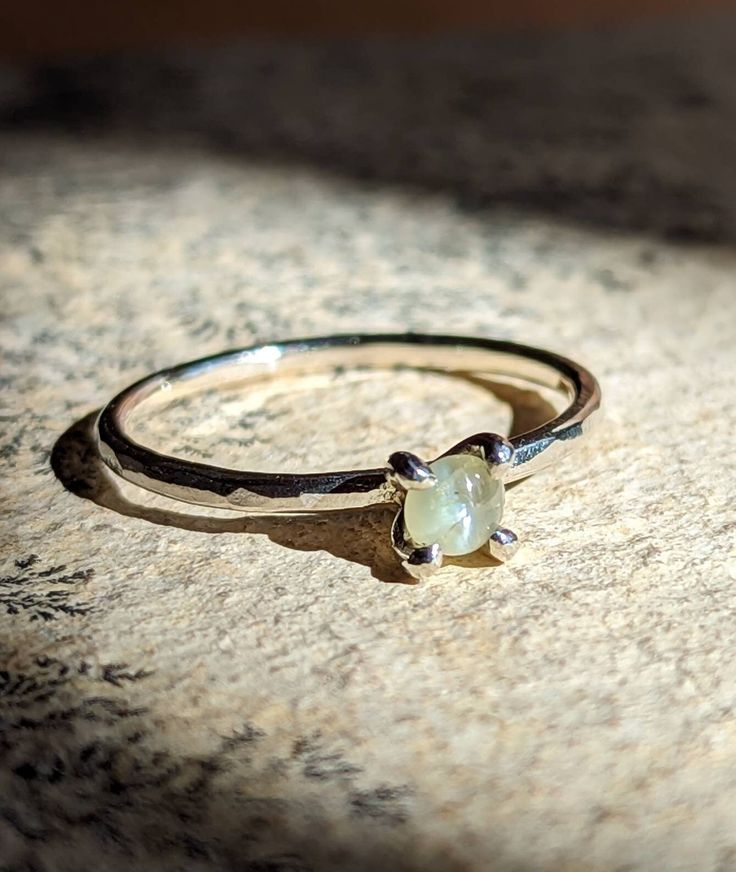 Der natürliche Katzenauge Chrysoberyll in diesem zarten Stapelring erstrahlt in einem atemberaubenden inneren Licht - das perfekte Geschenk für einen besonderen Menschen! Maße: 3mm Stein Stein: Echter natürlicher Katzenauge Chrysoberyll Farbe: Opalisierendes Silber-Weiß mit leichten Gelbstichen und einem starken Katzenaugeneffekt Metall: Fassung und Band handgemacht, wahlweise aus 935 Silber, Gold oder Gold Metalloberfläche: Gebürstet für ein glänzendes, seidiges Finish Größe: Wird in deiner Grö Delicate Stacking Rings, Cats Eye Ring, Girlfriend Christmas, Cats Eye Stone, Promise Ring Gift, Christmas Gifts For Girlfriend, Stack Ring, Inner Light, Ring Minimalist