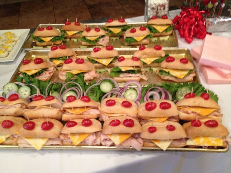 a table topped with lots of sandwiches covered in toppings