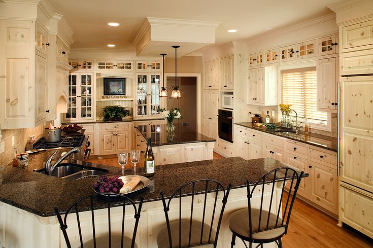 a kitchen with white cabinets and granite counter tops, along with two bar stools