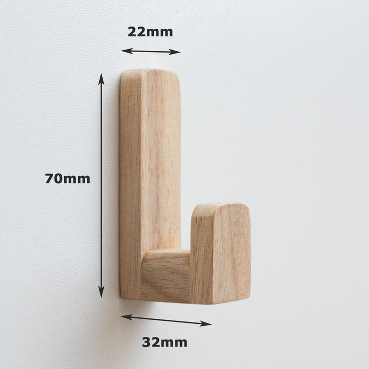 a wooden hook on the wall with measurements