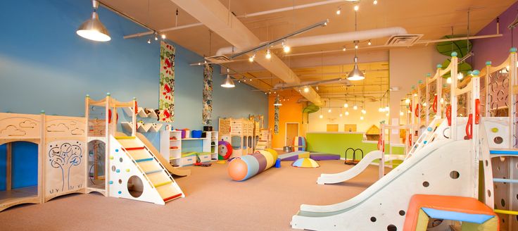 children's play area with slides and climbing equipment in large open space for indoor play