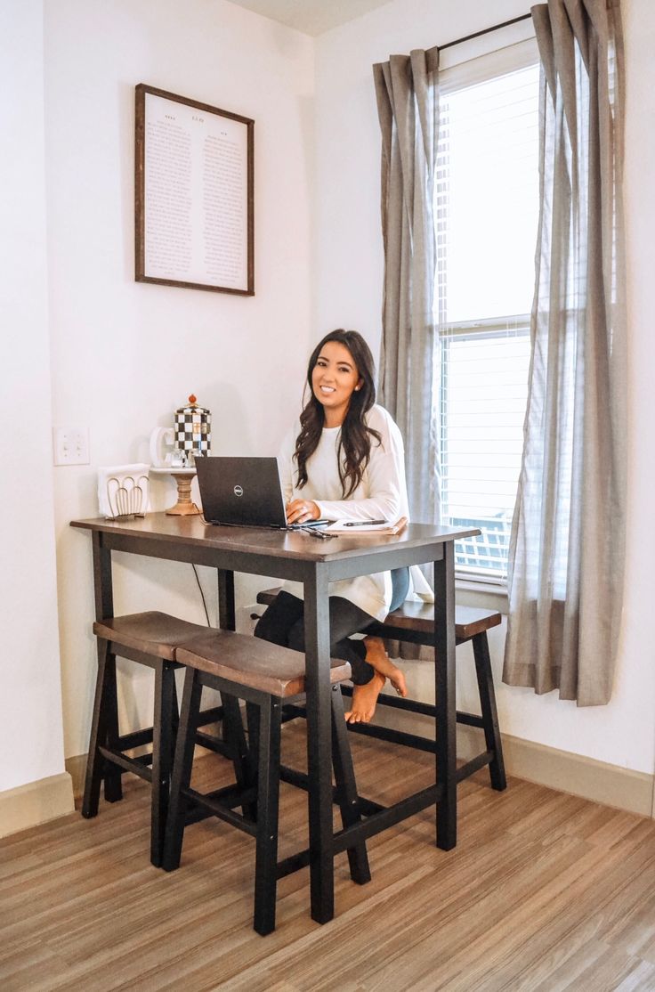 a woman sitting at a table with a laptop