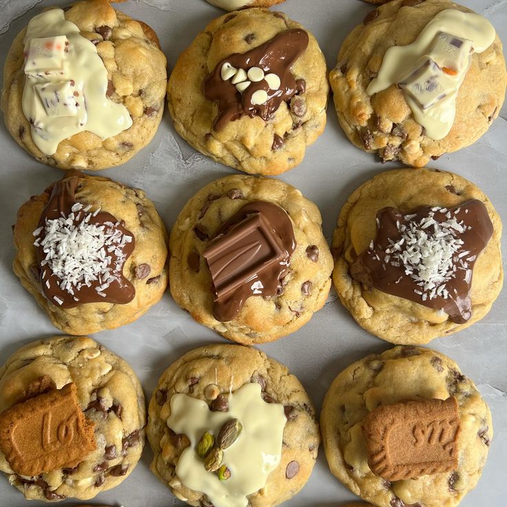 chocolate chip cookies are arranged in rows on a baking sheet with white icing and sprinkles