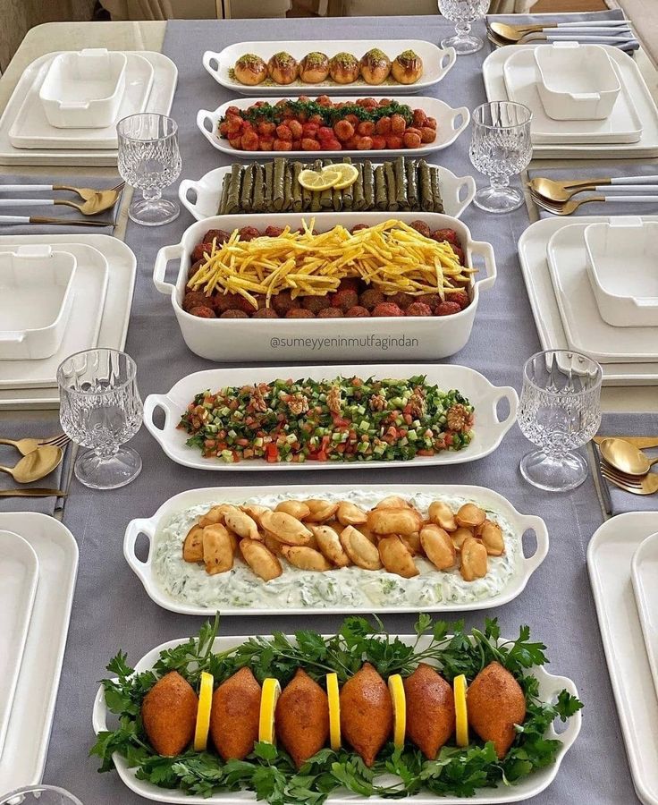 a table topped with lots of plates and bowls filled with different types of food items