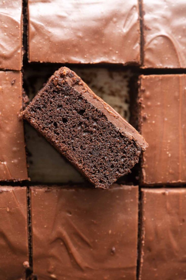 a piece of chocolate cake sitting on top of a brown tiled counter next to a knife