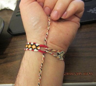 a person holding onto a colorful bracelet on their wrist