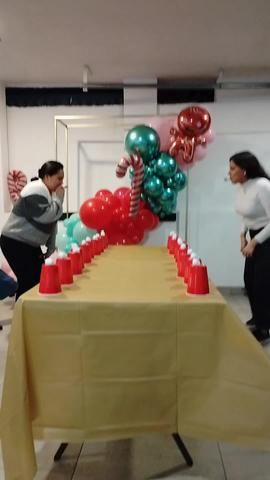 people standing around a table with balloons on it