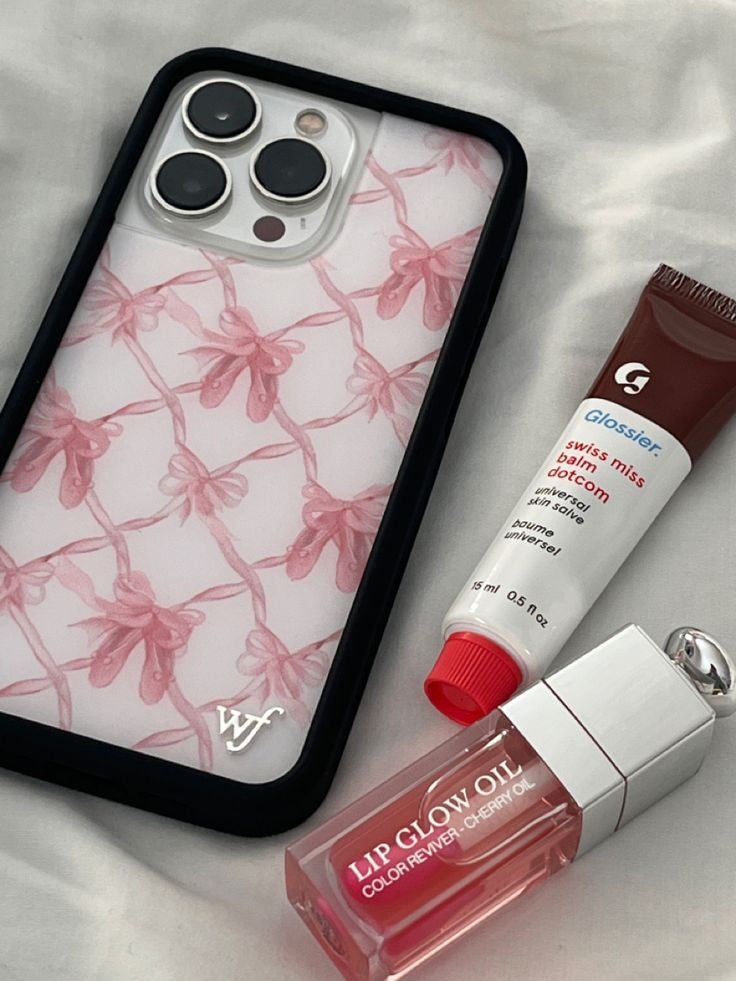 an iphone case with lipstick and lip glosses next to it