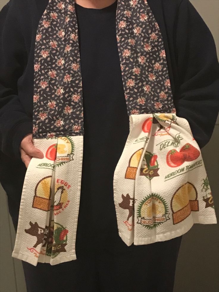 a person wearing a scarf with food images on it, and holding up their hands