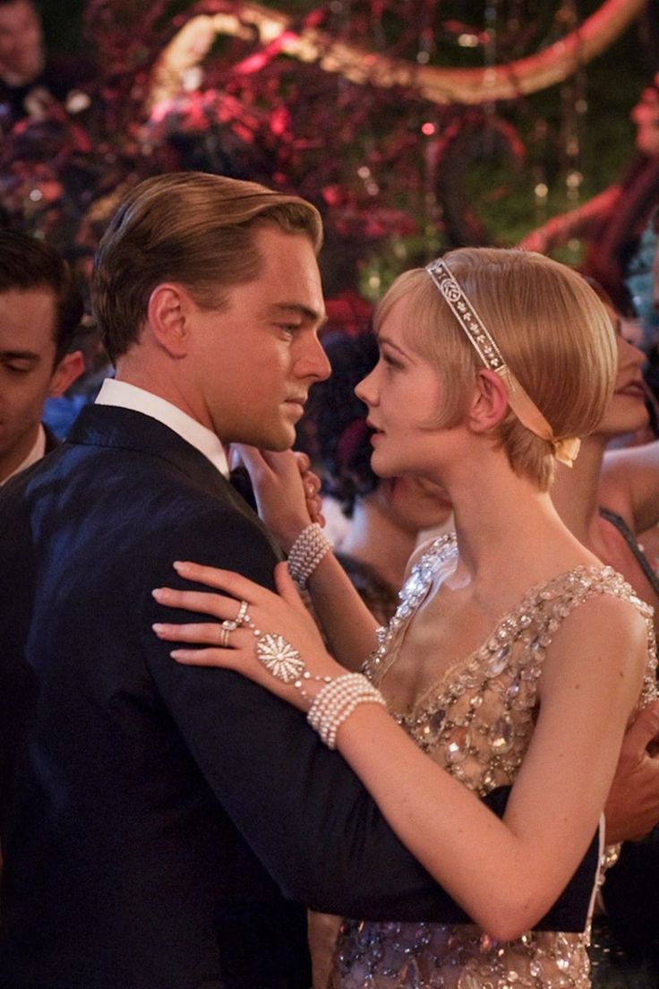 a man in a tuxedo and a woman in a sequin dress dance together