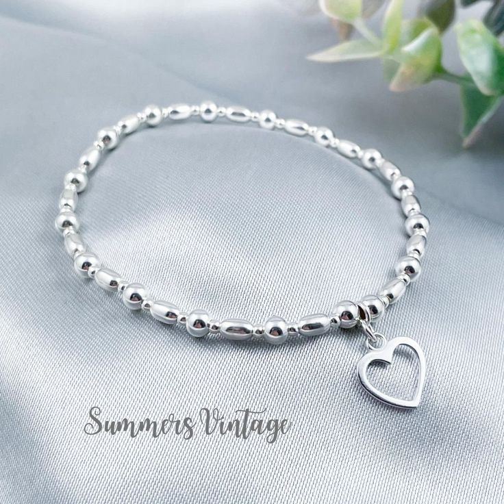 This simple and dainty sterling silver bracelet featuring a beautiful open-heart charm looks stunning worn alone or stacked alongside other bracelets for a Bohemian feel   The eclectic mix of beautiful beads are strung on high quality, strong, professional jewellers' elastic meaning there are no fiddly clasps to deal with, the bracelet can simply be rolled over the hand and onto the wrist The bracelet is elegantly presented in a beautiful jewellery pouch, complete with aftercare instructions and