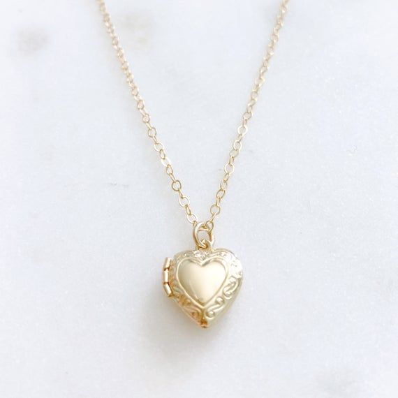 DESCRIPTION: The CHARLOTTE Necklace - Gold Heart Locket on a dainty gold filled chain. We love this sweet little necklace and think you will too! Insert a treasured photo and keep it close to your heart! The cutest way to show your love for someone special!MATERIALS:Chain, Clasp, Jump Rings - Gold Filled  Locket - Gold PlatedPENDANT SIZE:Approximately 1/2” in lengthPACKAGING:Your necklace will arrive on a Dainty Doe signature jewelry card placed in a white jewelry box, with a bow and tag, perfec Vintage Locket Charm Necklace For Mother's Day, Vintage Heart Pendant Charm Necklace For Mother's Day, Vintage Heart Pendant Charm Necklaces For Mother's Day, Vintage Charm Heart Pendant Necklace For Mother's Day, Mother's Day Heart Pendant Necklace With Vintage Charm, Mother's Day Vintage Charm Heart Pendant Necklace, Vintage Heart Charm Necklace, Vintage Gold Heart Charm Necklace, Yellow Gold Heart Necklace With Vintage Charm