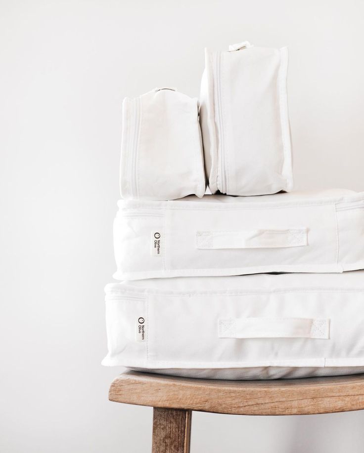 a stack of white sheets sitting on top of a wooden chair