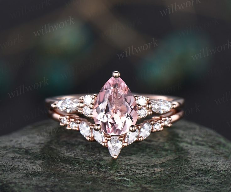 a pink diamond engagement ring on top of a rock with diamonds around the band and side stones